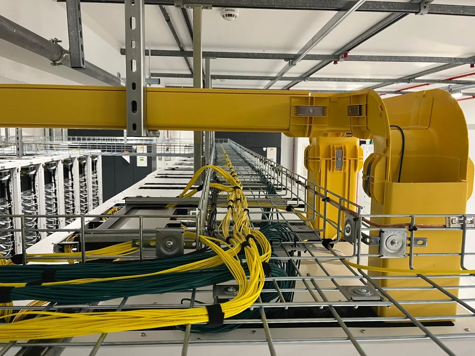 Vue rapprochée des cordons de fibre optique et des connexions dans une baie informatique.